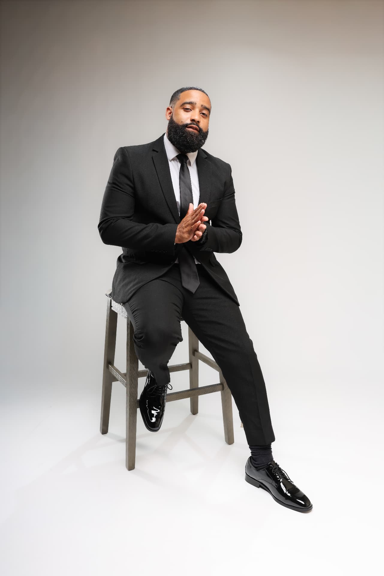 Luke Melton seated in a black suit